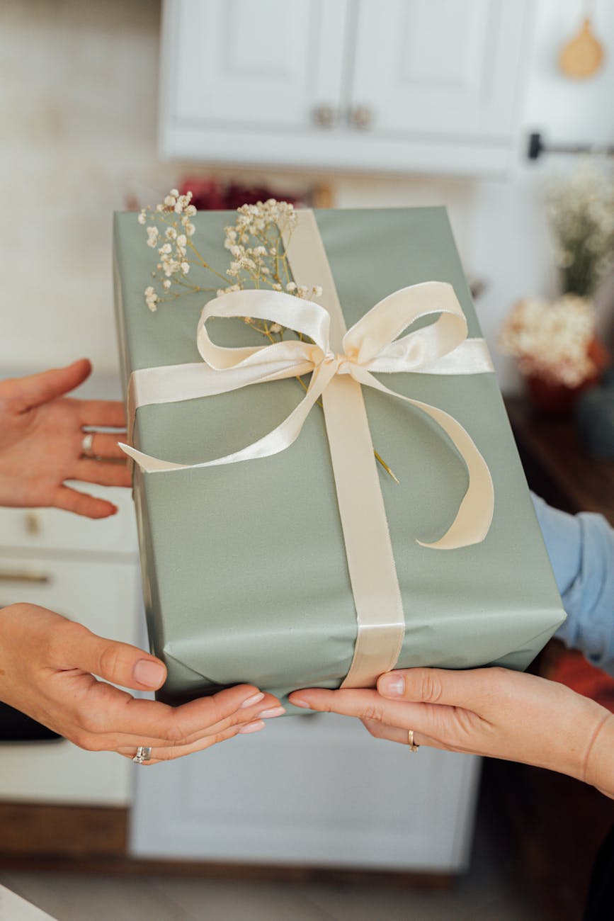person holding green and white floral gift box